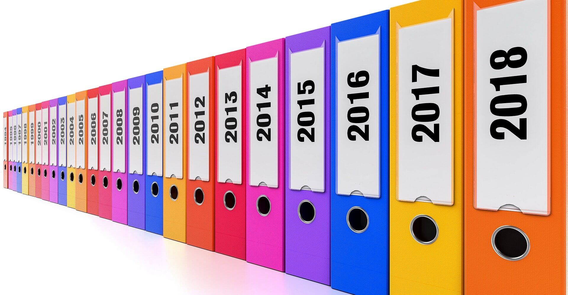 Rangée de classeurs colorés étiquetés par année - organisation des papiers administratifs Bahya Solutions Toulouse